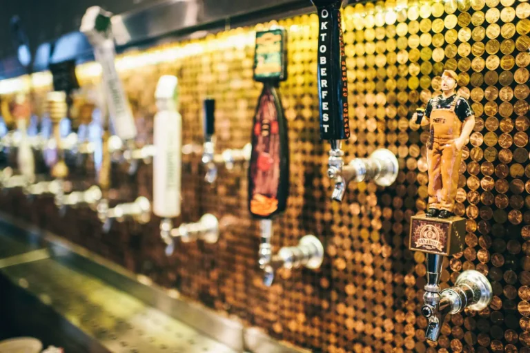 Close-up of craft beer tap handles mounted on a copper penny wall at Tap 42 Fort Lauderdale