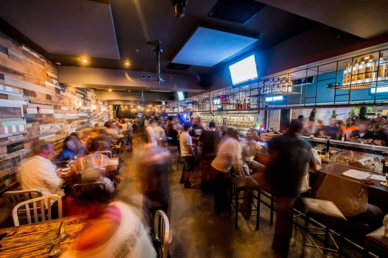 Busy evening crowd filling the bar and dining tables in motion blur at Tap 42 Fort Lauderdale