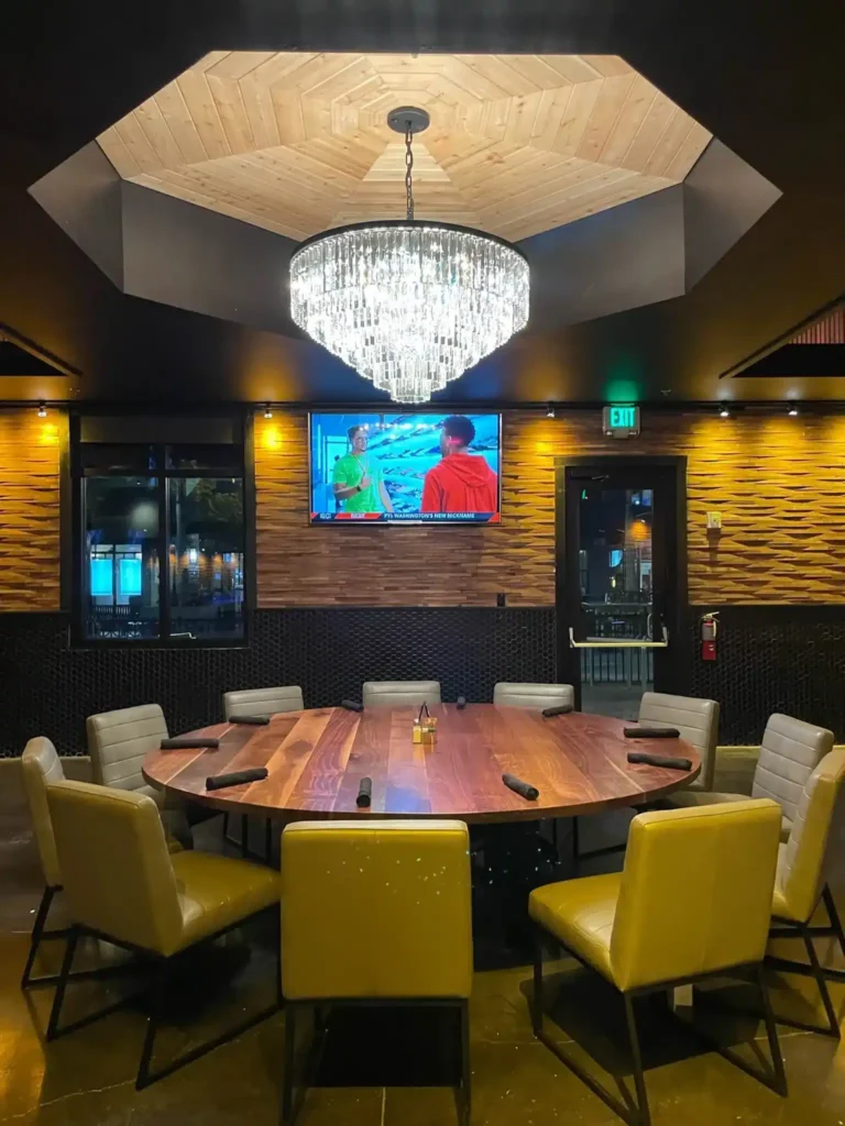Private dining room with a wood octagon ceiling, crystal chandelier and large round table at Tap 42 Kendall