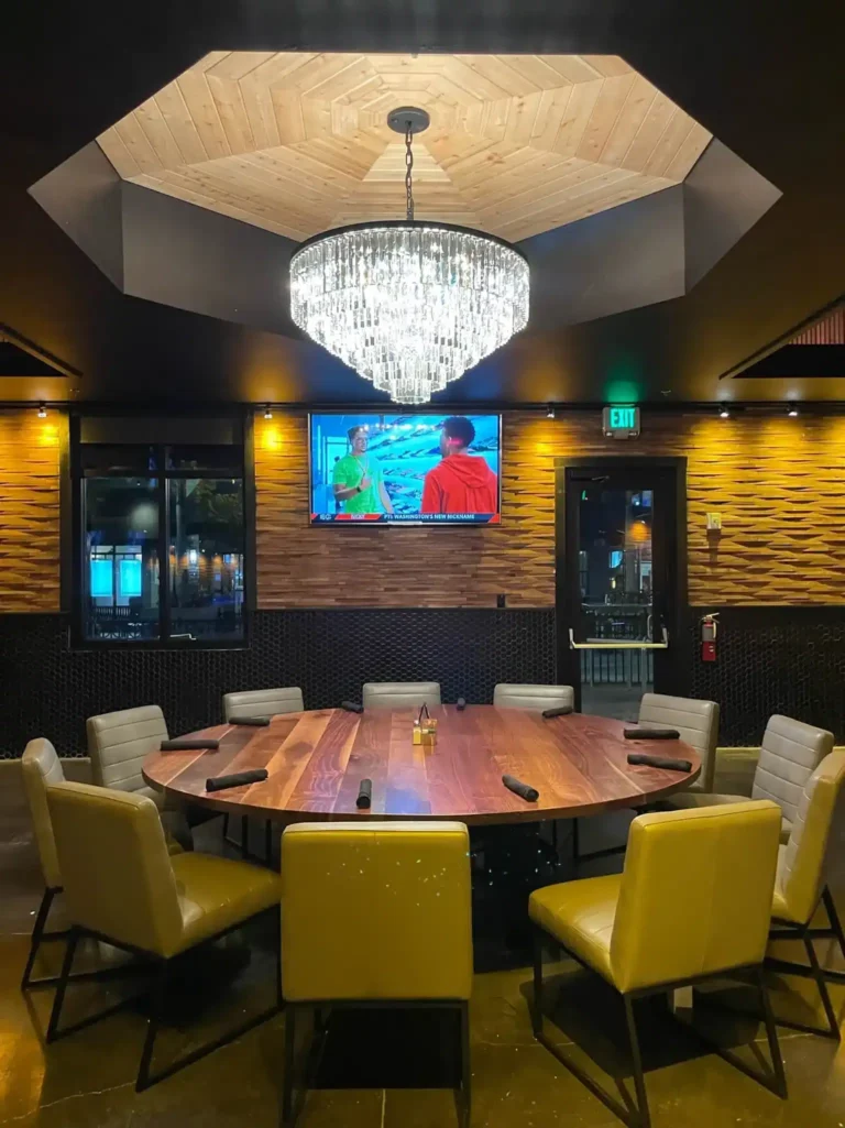 Private dining room with a wood octagon ceiling, crystal chandelier and large round table at Tap 42 Kendall