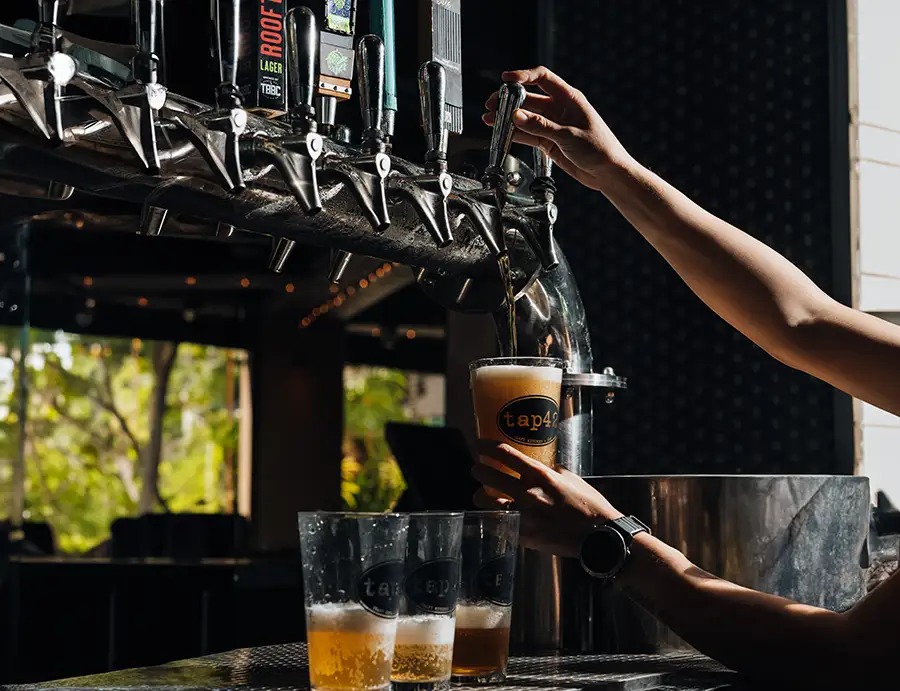 Bartender pouring craft beer from the taps