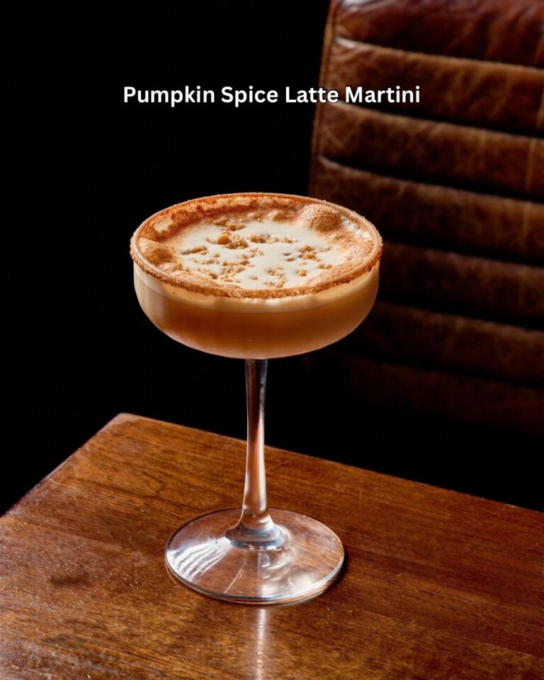 Pumpkin Spice Latte Martini with a foamy, cinnamon-dusted top and spiced rim in a coupe glass on a wood table at Tap 42